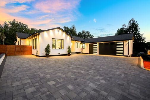 Modern ADU exterior at dusk with paver driveway
